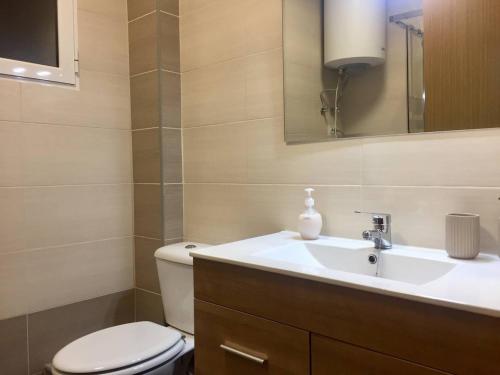 a bathroom with a sink and a toilet and a mirror at Apartamento en Universidad y cerca de la playa in Valencia