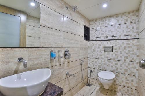 a bathroom with a sink and a toilet at Hotel Pearl in Vadodara