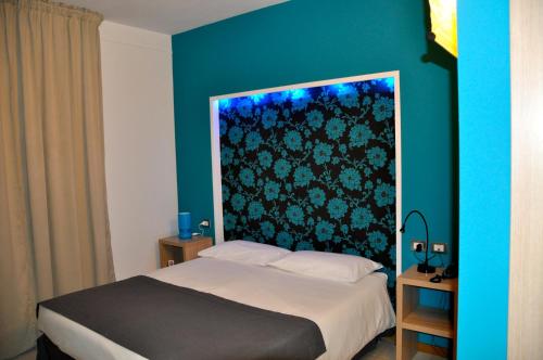 a bedroom with a bed with a blue wall at Letto & Riletto in Montecassiano