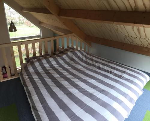Bett in einem Zimmer im Dachgeschoss in der Unterkunft Huisje op Hamingen in Staphorst