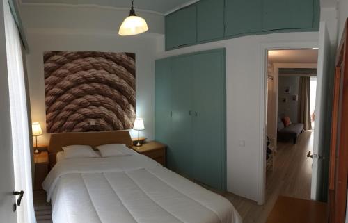 um quarto com uma grande cama branca com um quadro na parede em Flat31 em Atenas