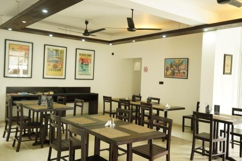 a dining room with wooden tables and chairs at Chapelton House in Colombo