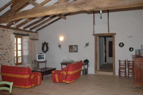 a living room with couches and a table and a room with a tablektop at Villa Gites Chambre d hôtes avec piscine Dordogne 2-4-6-8-10 personnes in Bussière-Badil