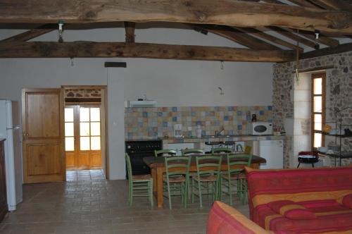 a kitchen and dining room with a table and chairs at Villa Gites Chambre d hôtes avec piscine Dordogne 2-4-6-8-10 personnes in Bussière-Badil