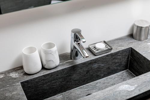 a bathroom sink with two cups and a faucet at 7132 Glenner in Vals