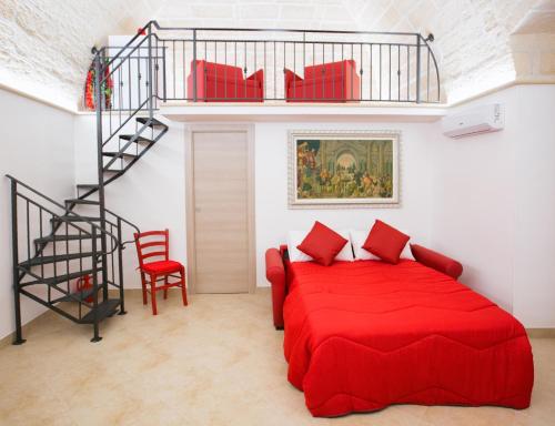una camera con letto rosso e scala a chiocciola di Il Galante B&B casa vacanza a Ginosa
