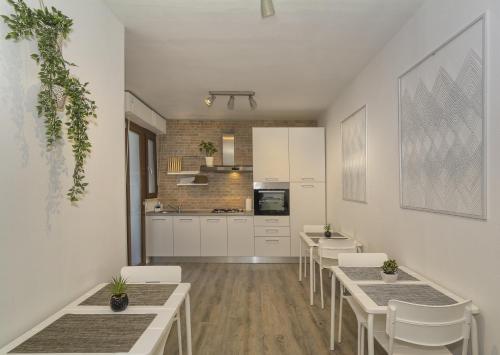 a room with tables and chairs and a kitchen at Affittacamere L'APPRODO in Pisa