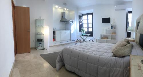 a bedroom with a large bed and a kitchen at Casco Historico Apt. Doña Concha in Ronda