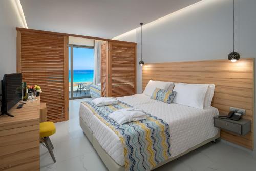 a bedroom with a bed with a view of the ocean at Avra Beach Resort in Ixia