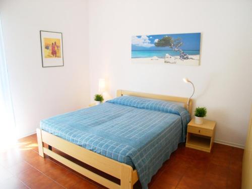 a bedroom with a bed with a blue blanket at Appartamento Saturnia in Grado