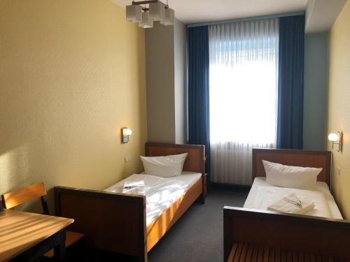 Un pat sau paturi într-o cameră la Haus des Volkes - Das Bauhaushotel