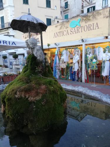 a statue of a person holding an umbrella in front of a store at IL PARADISO DEGLI DEI 2 in Agerola