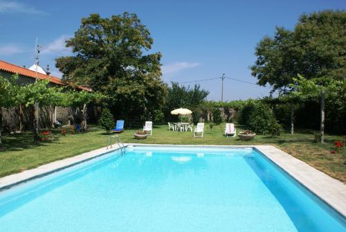 a swimming pool in a yard with a table and chairs at Quinta de Santa Baia in Gaifar