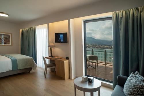 a hotel room with a bed and a large window at Chios Chandris in Chios