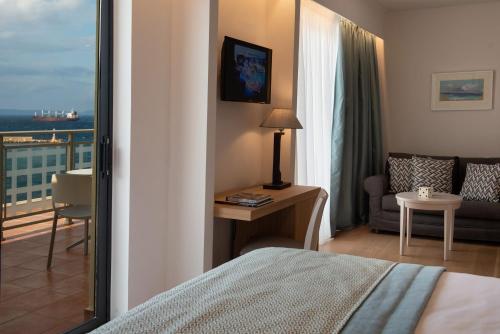 a hotel room with a bed and a balcony at Chios Chandris in Chios