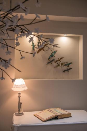 a lamp sitting on a table next to a book and a branch at Irini Hotel in Heraklio Town