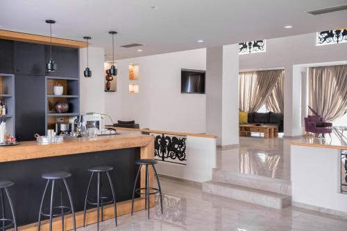 a kitchen and living room with a counter and stools at Irini Hotel in Heraklio Town