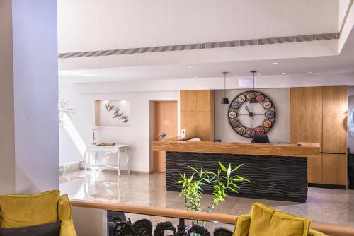 a living room with a large clock on the wall at Irini Hotel in Heraklio Town