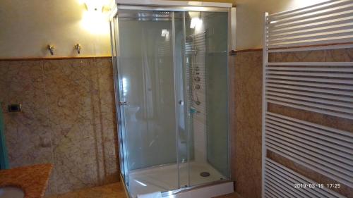 y baño con ducha y puerta de cristal. en Casa del Sole, en Venturina Terme