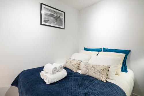 een slaapkamer met een bed met handdoeken erop bij Le Plongeoir by Cocoonr in Saint-Malo