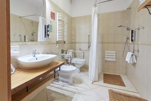 a bathroom with a sink, toilet and bathtub at Hotel Batory in Krakow
