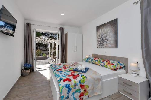 ein weißes Schlafzimmer mit einem Bett und einem Fenster in der Unterkunft Apartman-Studio Meri in Makarska