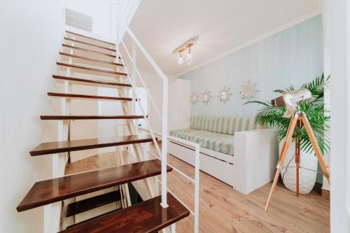 una escalera en una sala de estar con un banco en Paul do Mar Beach House, en Paul do Mar