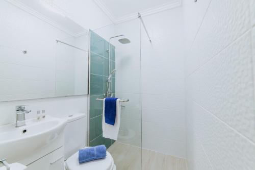 Un baño blanco con lavabo e inodoro. en Paul do Mar Beach House, en Paul do Mar