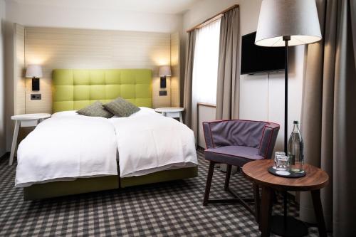 ein Hotelzimmer mit einem Bett und einem Stuhl in der Unterkunft 7132 Glenner in Vals
