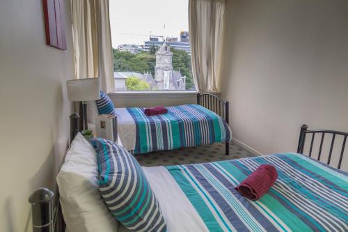 a bedroom with two beds and a large window at Choice Backpackers in Auckland