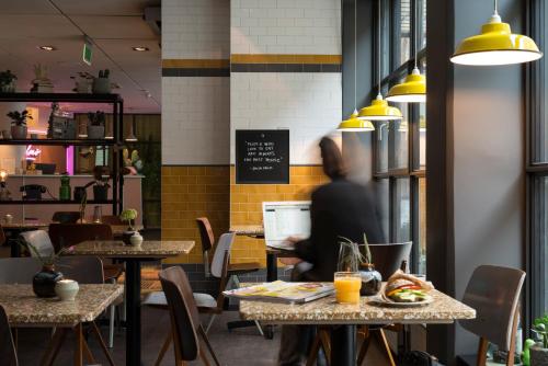 a person sitting at a table in a restaurant at Best Western Plus Hotel Noble House in Malmö