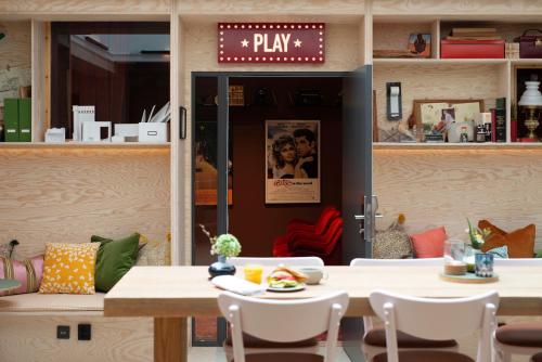 a restaurant with a table and chairs and a play sign at Best Western Plus Hotel Noble House in Malmö
