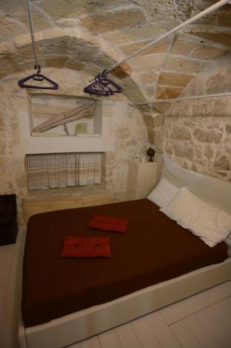 a bedroom with a bed in a stone wall at B&B DOMUS GAIA in Lecce