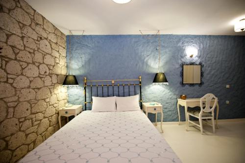 1 dormitorio con cama y pared azul en Mercan Köşk, en Alacati