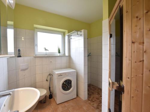 a bathroom with a washing machine and a sink at Gemuetliches Ferienhaus in Zierow mit Sauna in Zierow