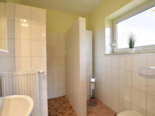a bathroom with a sink and a toilet and a window at Peaceful Apartment in Zierow with Terrace in Zierow