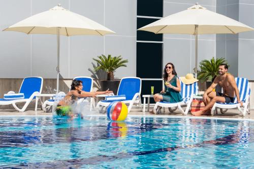 a group of people playing in a swimming pool at Gulf Court Hotel Business Bay in Dubai