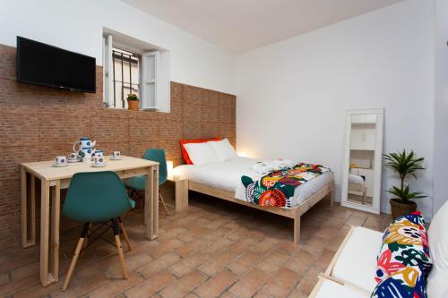 1 dormitorio con cama, mesa, mesa y sillas en Corral del Conde, en Sevilla