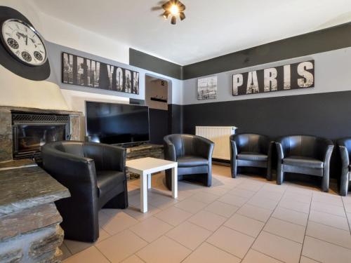 a waiting room with leather chairs and a fireplace at Modern Home with Bubble Bath and Sauna in Bra in Lierneux