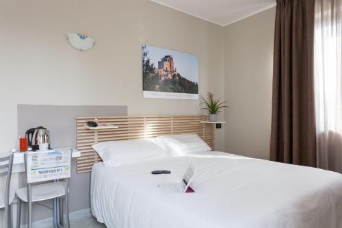 a bedroom with a large white bed and a desk at Green Class Hotel Candiolo in Candiolo