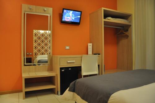 a bedroom with a bed and a mirror and a tv at Letto & Riletto in Montecassiano