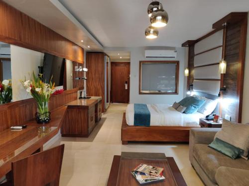 a large bedroom with a bed and a couch at Fairway Boutique Hotel - Kampala, Uganda in Kampala