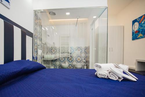 a bedroom with a blue bed with towels on it at OASI FANTASIA in Agerola
