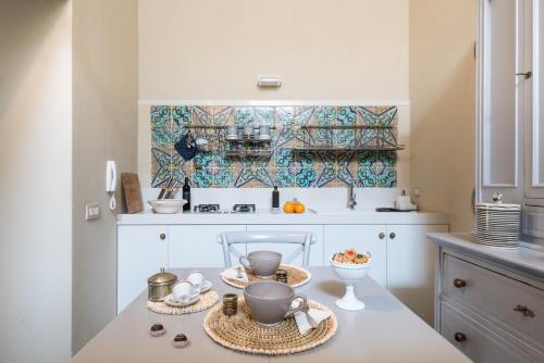 una cucina con tavolo e stoviglie di Jasmine Modica Luxury House a Modica