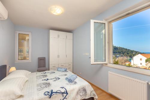 um quarto com uma cama e uma grande janela em Finnella em Dubrovnik