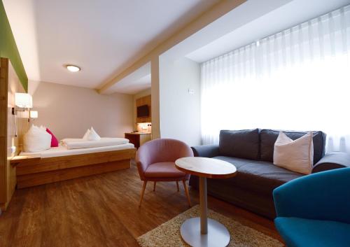 a living room with a couch and a table at Hotel & Gasthof Richard Held in Regensburg