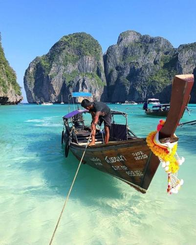 a man is on a boat in the water at Phi Phi Maiyada Resort in Phi Phi Don