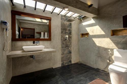 a bathroom with a sink and a mirror at Kubura Resort in Anuradhapura