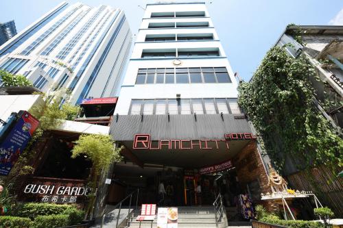 a tall white building with a store in front of it at Ruamchitt Plaza Hotel in Bangkok