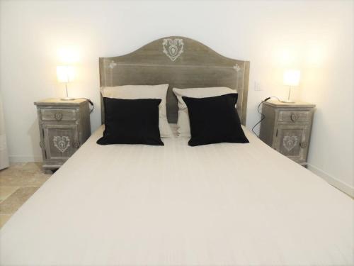a large bed with two nightstands and two lamps at L’écurie location saisonnière in Tavernes